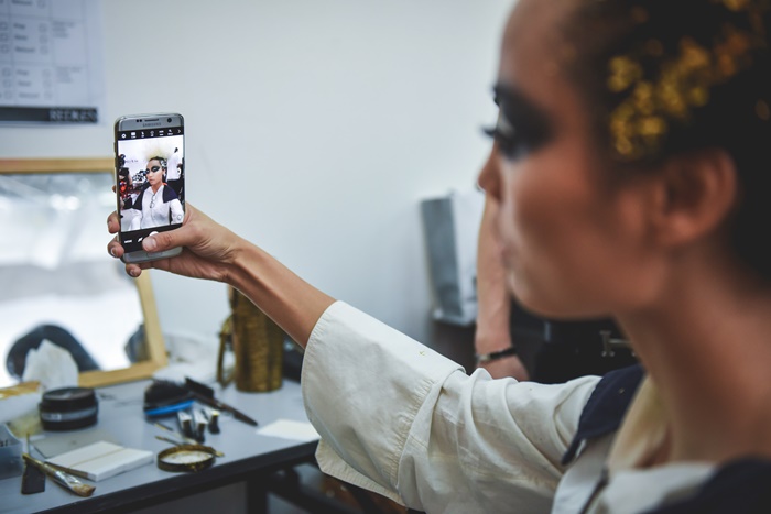 Behind the scenes, a model snaps a selfie on the Galaxy S7 edge.jpg